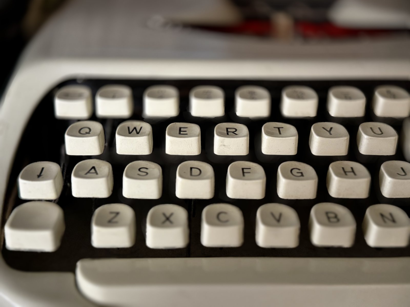 Extreme close-up of glass typewriter keytops, decades of fingerprints visible.