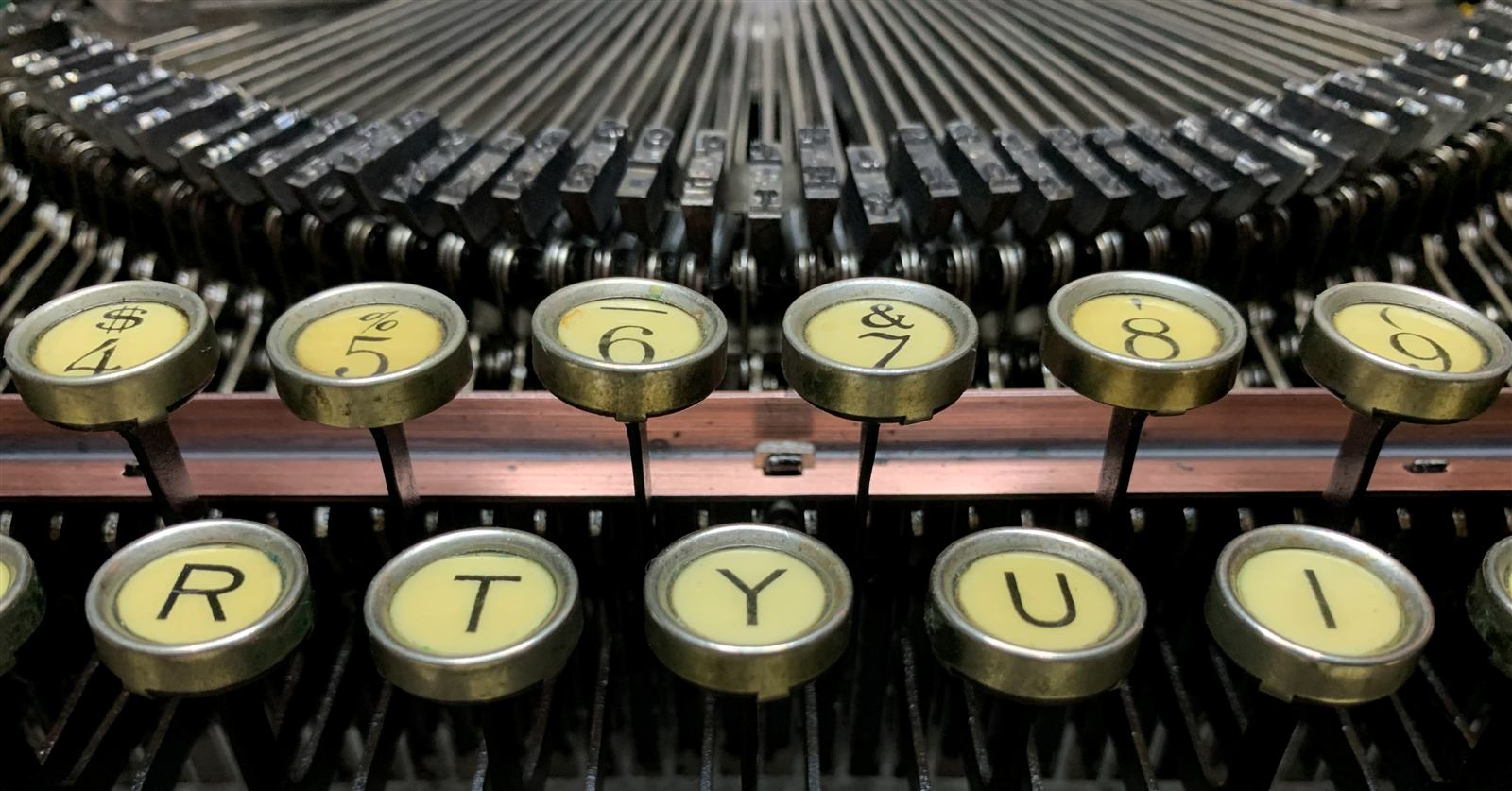 Macro close-up of round glass-topped number and letter keys and their levers.