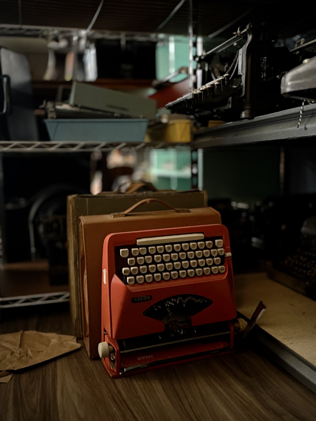 A red typewriter sitting on the shop floor, mid-move.