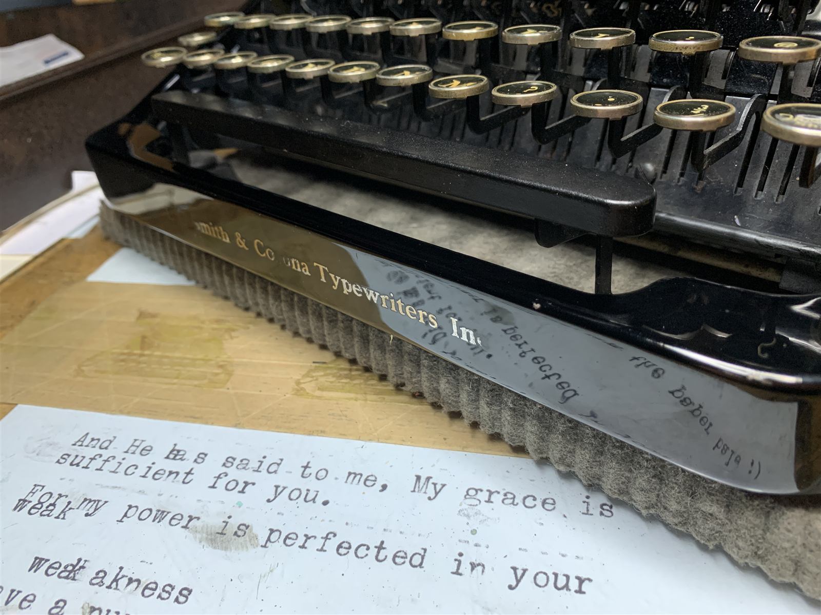Close-up of a Smith-Corona typewriter's nameplate resting over an old typed page.